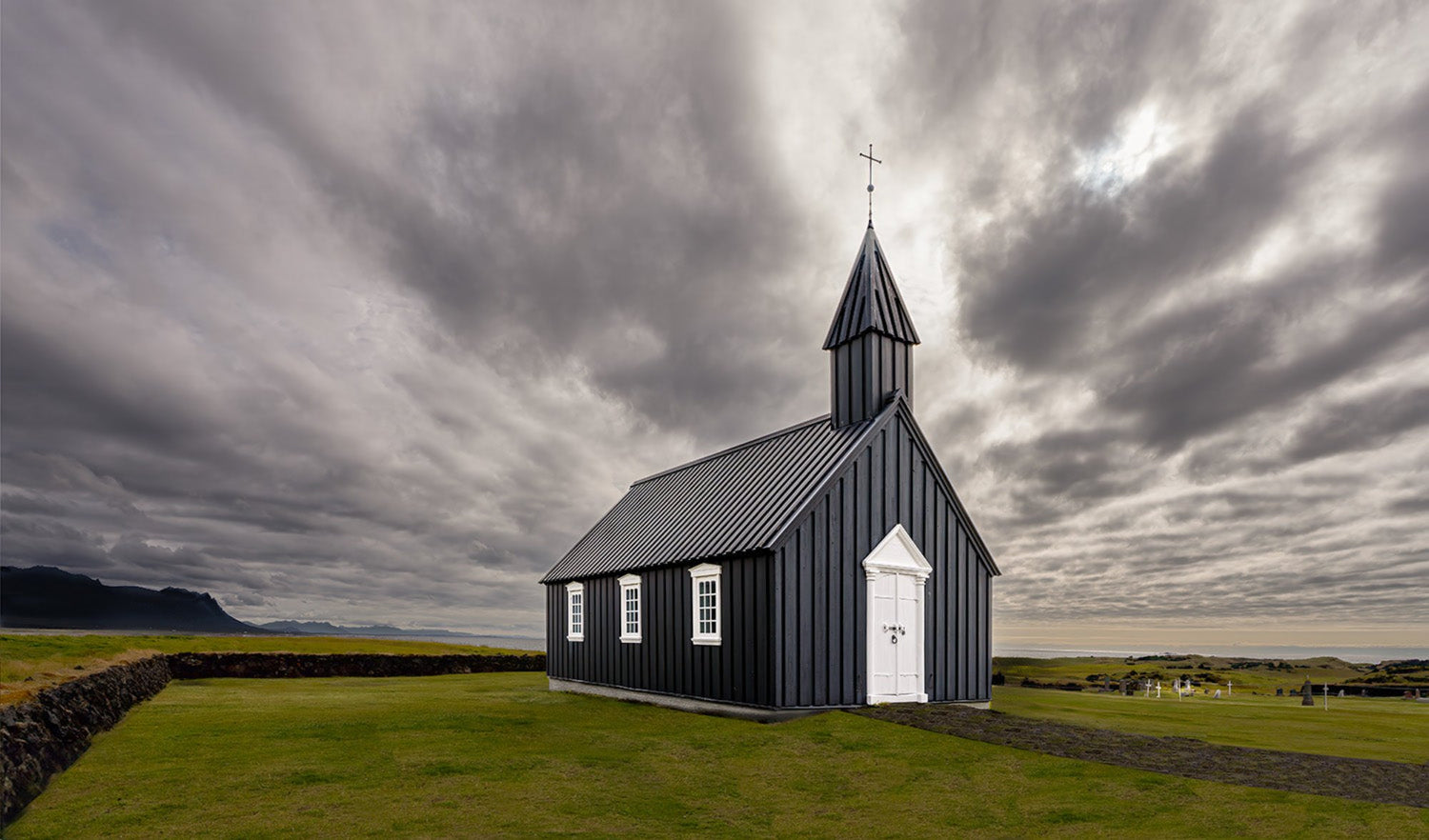 Búðakirkja, het beroemde zwarte kerkje van IJsland, tegen een dramatische lucht
