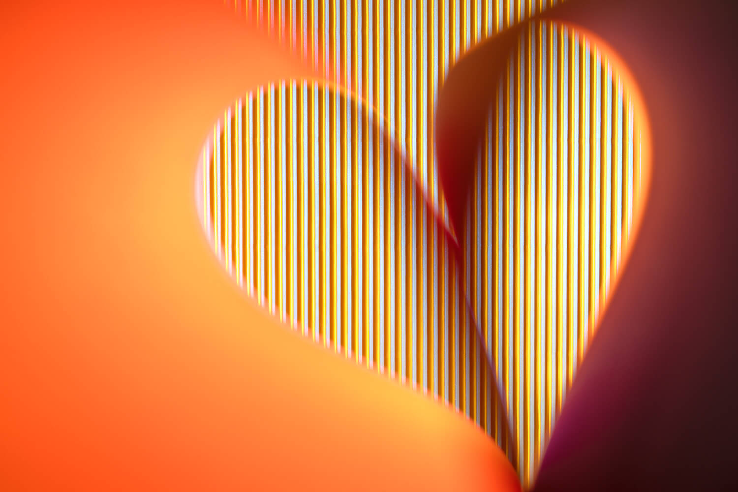 Abstract beeld van oranje en rood licht met verticale lijnen, die een dynamisch spel van kleuren en schaduwen vormen. - Foto Luc Maes