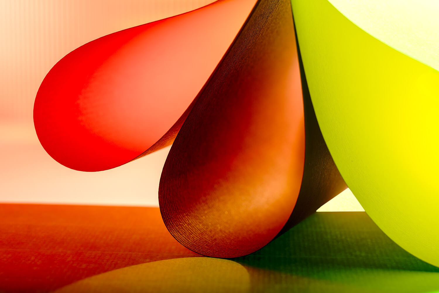 Abstract beeld met golvende vormen in heldere rood, oranje, en gele tinten, met een speels schaduwspel. - Foto Luc Maes