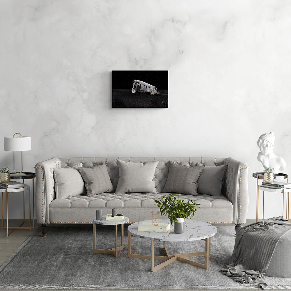 Wanddecoratie met het verlaten vliegtuigwrak van de Dakota DC-3 op een IJslands strand, formaat 60x40cm, tegen een donkere sterrenhemel.