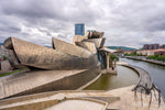 Zijaanzicht van het Guggenheim Museum in Bilbao, met moderne metalen panelen en gebogen lijnen