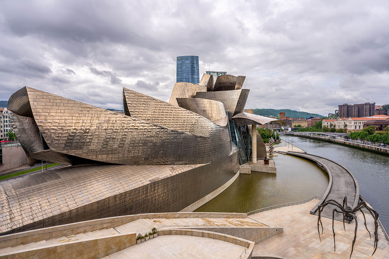 Zijaanzicht van het Guggenheim Museum in Bilbao, met moderne metalen panelen en gebogen lijnen