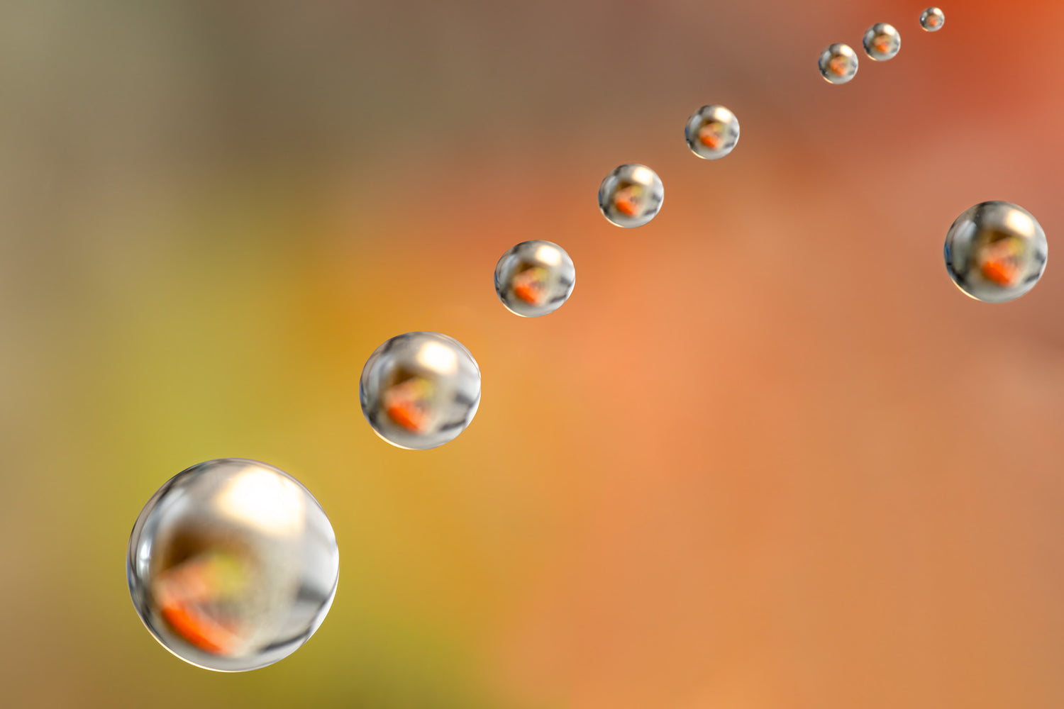 Abstracte afbeelding van zwevende waterdruppels op een warme oranje achtergrond, met reflecties van natuurlijke kleuren.