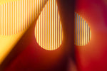 Abstracte close-up van kleurrijke lichtstralen in rode en gele tinten, die een harmonieuze interactie creëren.- Foto Luc Maes