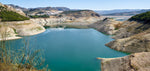 Uitzicht op het serene Iznájar Reservoir in Andalusië, Spanje, omringd door heuvels en groene bossen.