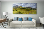 Groot panorama canvas van de Schotse Highlands, formaat 180x120cm, in een stijlvol interieur.